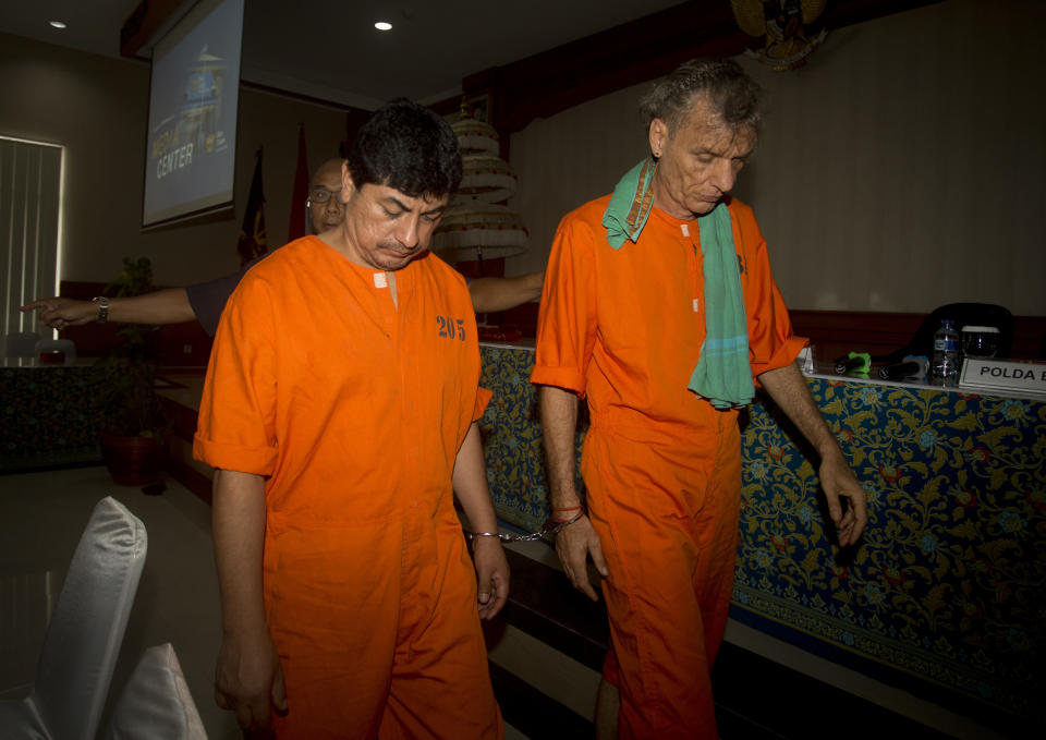 Peruvian Jorge Albornoz Gamarra, left, and German Frank Zeldler, right, walk after a press conference in Bali, Indonesia on Thursday, Dec. 13, 2018. Indonesian police say some of the five foreigners arrested for drug smuggling on the tourist island of Bali since the end of November face the death penalty if convicted. Police paraded the citizens of Peru, Britain, China, Malaysia and Germany at a press conference Thursday in Denpasar, the capital of Bali province.(AP Photo/Firdia Lisnawati)