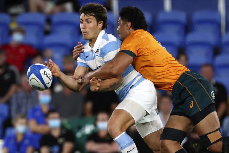 El medioscrum Gonzalo Bertranou, a la izquierda, pasa bajo la presión de la defensa australiana durante un partido del Rugby Championship en Gold Coast, Australia, el sábado 2 de octubre de 2021.