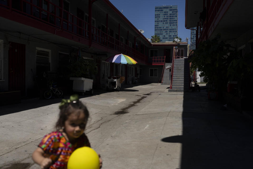 La hermanita de Deneffy Sánchez, Jennifer, juega en el patio debido a que su compañero de piso exige silencio en el apartamento tipo estudio que comparten, el martes 29 de agosto de 2023, en Los Ángeles. La pérdida de empleos durante la pandemia de COVID-19, aunada al alza en las rentas, ha obligado a muchos residentes de California a aceptar condiciones de vivienda desesperadas. (AP Foto/Jae C. Hong)