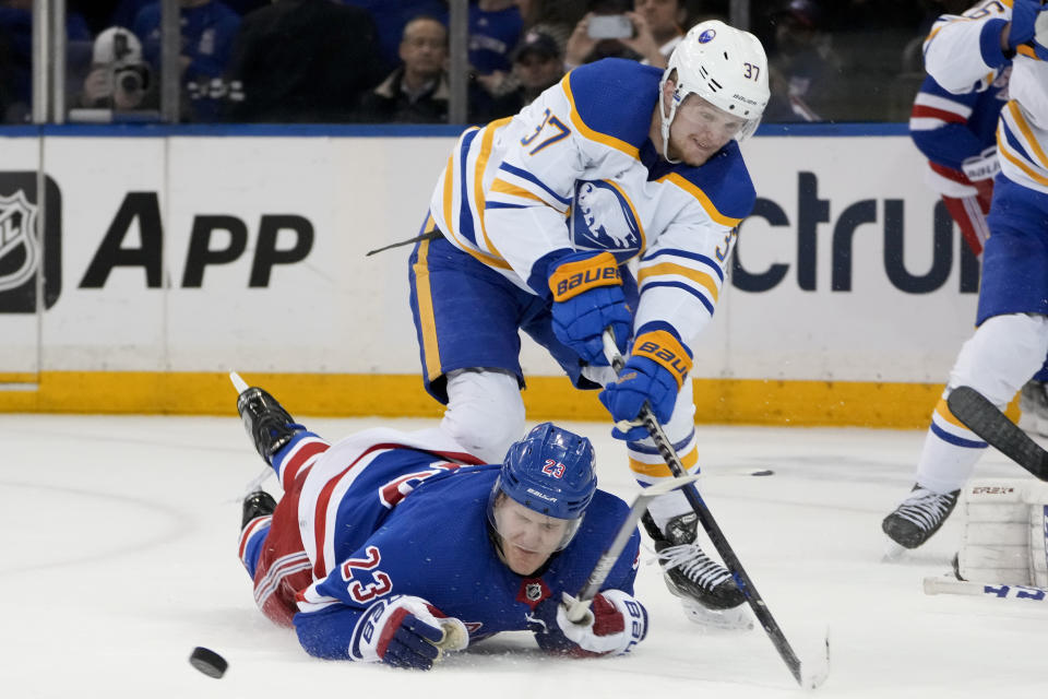 Buffalo Sabres center Casey Mittelstadt (37) and New York Rangers defenseman Adam Fox (23) battle for the puck during the third period of an NHL hockey game, Monday, April 10, 2023, in New York. (AP Photo/John Minchillo)