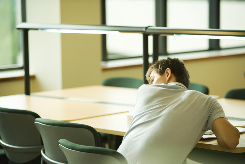 student peeking over their shoulder as to not get caught cheating