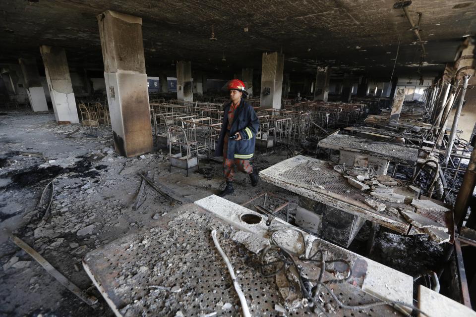 A firefighter inspects the Standard Group garment factory which was on fire in Gazipur