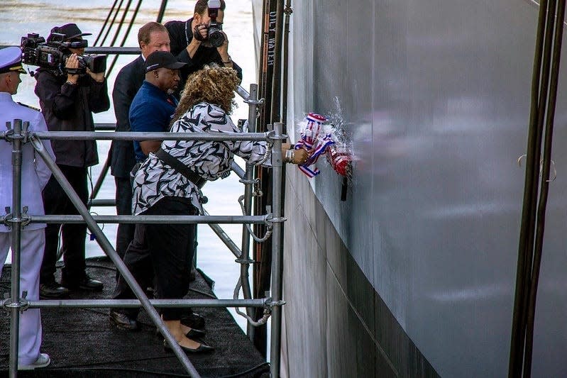 Patricia Sargent, the ship sponsor, christens Military Sealift Command's newest ship, expeditionary sea base USS John L. Canley.