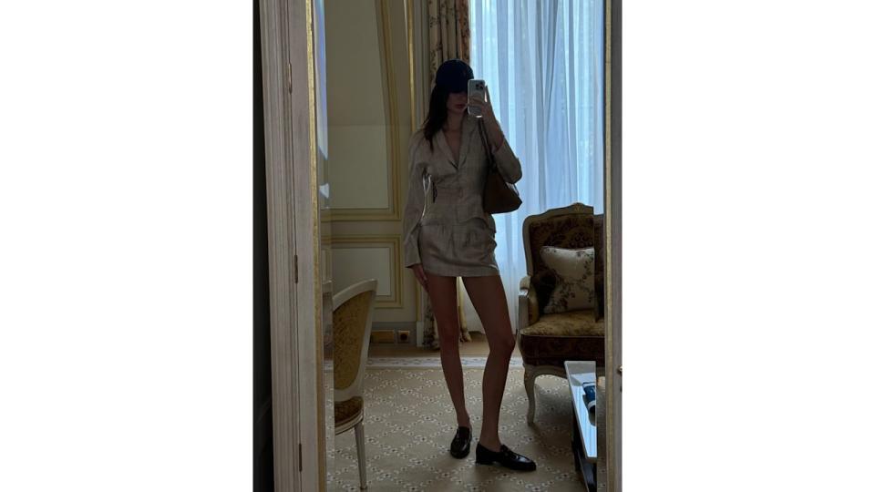 Kendall Jenner poses in a mini skirt and matching blazer in her Paris hotel room