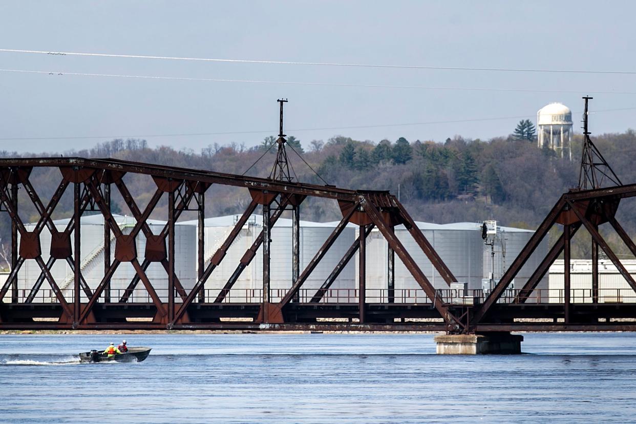 A boat tries to pass under a train bridge as the Mississippi River floods in April in Dubuque.