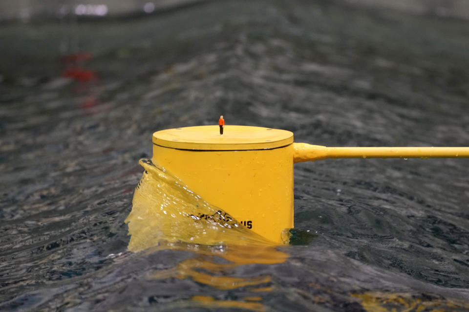 A figure represents a human standing on a vertical column used to stabilize a floating wind turbine in the wave pool, Wednesday, March 27, 2024, at the University of Maine, in Orono, Maine. (AP Photo/Robert F. Bukaty)