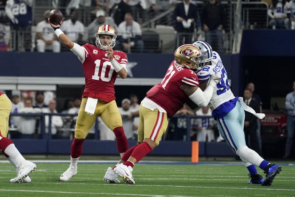 San Francisco 49ers quarterback Jimmy Garoppolo (10) throws a pass as offensive tackle Trent Williams (71) helps against pressure from Dallas Cowboys defensive end Dorance Armstrong (92) in the first half of an NFL wild-card playoff football game in Arlington, Texas, Sunday, Jan. 16, 2022. (AP Photo/Tony Gutierrez)