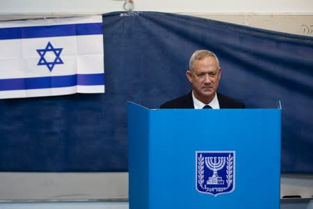 Leader of Blue and White party, Benny Gantz stands behind a voting booth as he votes in Israel's parliamentary election at a polling station in Rosh Ha'ayin, Israel