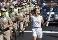 <p>Coca-Cola Torch Bearer Alessandra Ambrosio has the ultimate #ThatsGold moment as she runs with the Olympic flame through Rio de Janeiro on August 5, 2016 in Rio de Janeiro, Brazil. (Photo by Buda Mendes/Getty Images for Coca-Cola) </p>