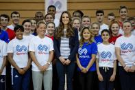 Britain's Catherine, Duchess of Cambridge (C) poses with young athletes for a group photograph as she attends a SportsAid athlete workshop at the Copper Box in the Olympic Park in London October 18, 2013. REUTERS/David Bebber/Pool (BRITAIN - Tags: ROYALS ENTERTAINMENT SPORT)