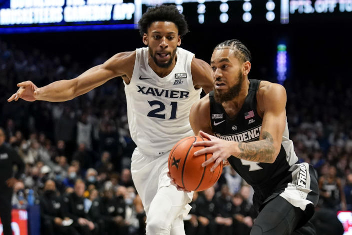 Providence guard Jared Bynum (4) drives for the basket past Xavier's Jerome Hunter (21) during the first half of an NCAA college basketball game, Wednesday, Jan. 26, 2022, in Cincinnati. (AP Photo/Jeff Dean)