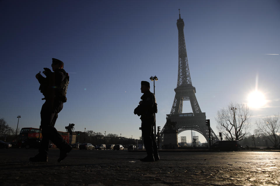 FILE - Riot police officers patrol near the Eiffel Tower Monday, Dec. 30, 2019 in Paris, two days before New Year's Day. Security will be tight across France on New Year's Eve, with 90,000 law enforcement officers set to be deployed throughout the country, domestic intelligence chief Céline Berthon said Friday Dec.29, 2023. (AP Photo/Christophe Ena, File)