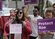 <p>Hillary Namba, left, of Seattle, holds a wire coat hanger and a sign that reads “We Won’t Go Back,” Tuesday, July 10, 2018, as she takes part in a protest in Seattle against President Donald Trump and his choice of federal appeals Judge Brett Kavanaugh as his second nominee to the Supreme Court. (Photo: Ted S. Warren/AP) </p>