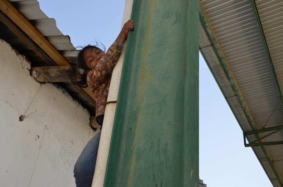 Gabriela, la niña indígena de la policía comunitaria, trepándose a una columna que sostiene la cancha de Ayahualtempa / Foto cortesía de Norma Scarlett García Arias.