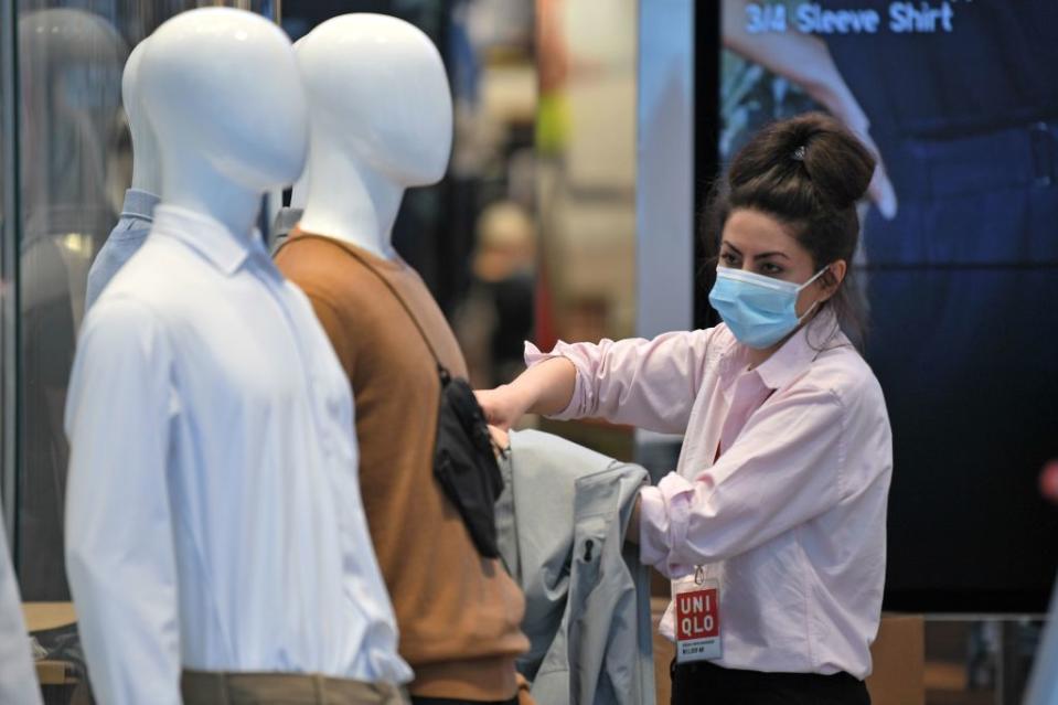 A shop worker gets ready to welcome customers to Uniqlo in London. (Getty Images)