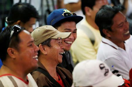 Filipino workers who were repatriated by the Philippine government from Saudi Arabia, laugh as they listen to the speech by Philippine President Rodrigo Duterte after arriving at the Ninoy Aquino International Airport in Manila, Philippines August 31, 2016. REUTERS/Erik De Castro