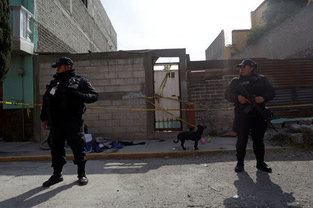 Police keep watch outside the home where according to local authorities five inhabitants died after the car of a cargo train ran off the tracks knocking their home in the municipality of Ecatepec, on the outskirts of Mexico City, Mexico January 18, 2018. REUTERS/Daniel Becerril