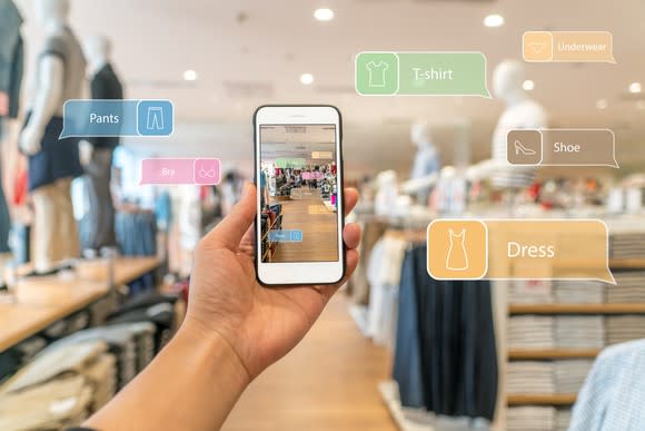 A hand holds a smartphone with an augmented reality (AR) shopping guide