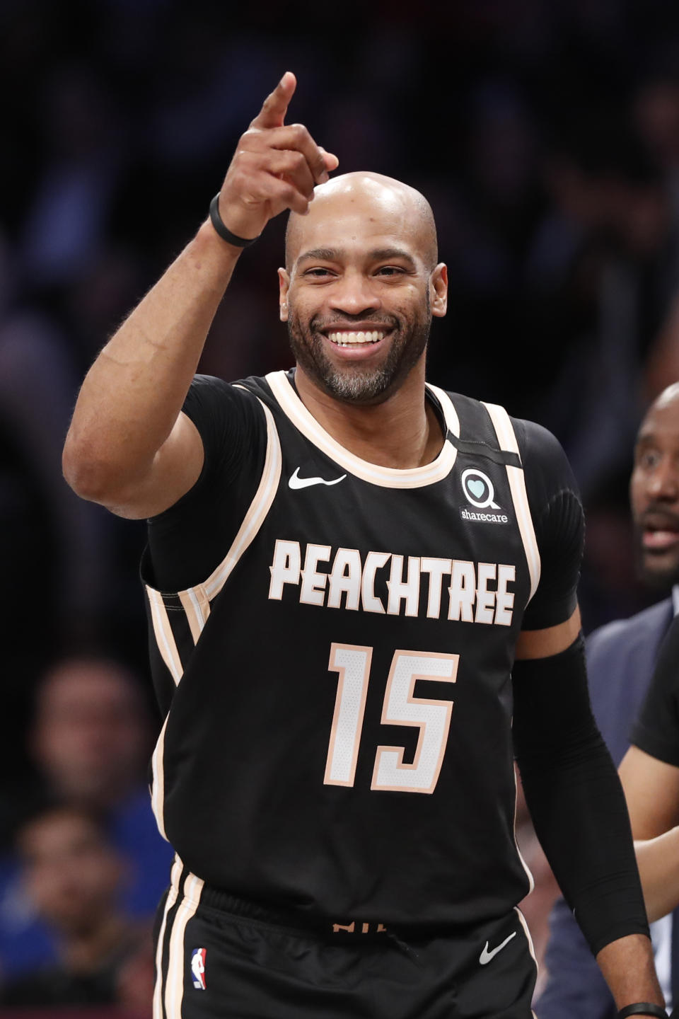 Atlanta Hawks guard Vince Carter (15) reacts as the crowd cheers his second appearance on the court during the first half of an NBA basketball game against the Brooklyn Nets, Sunday, Jan. 12, 2020, in New York. (AP Photo/Kathy Willens)