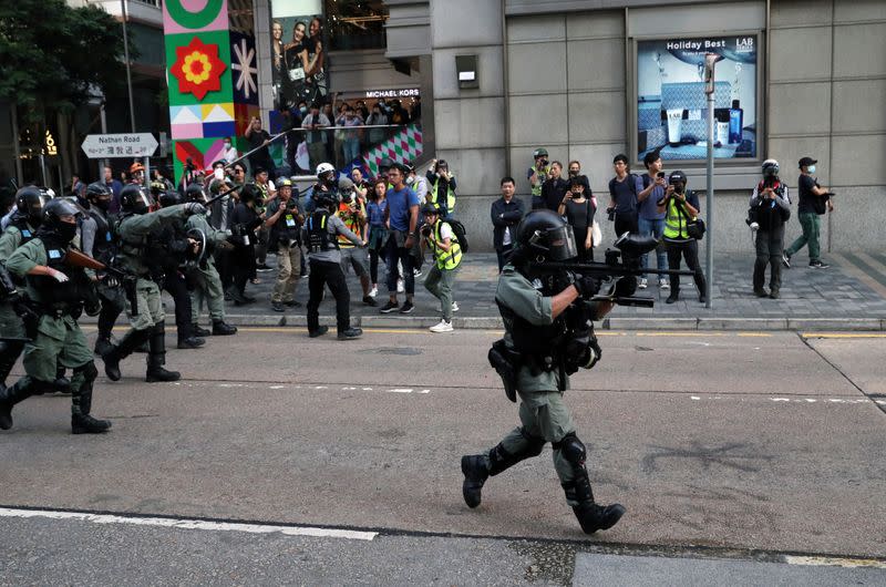 Riot police officers charge towards anti-government protesters during the "Lest We Forget" rally in Hong Kong