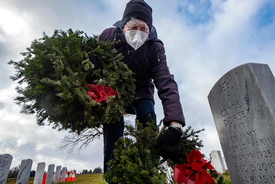 Charlene Lindsey, of Holland, picks up another wreath from the gravesites at Washington Crossing National Cemetery in Upper Makefield on Monday, Jan. 17, 2022.