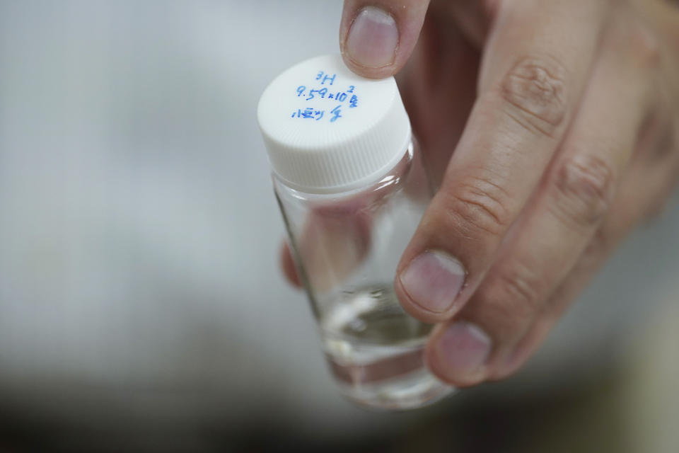 University of Tokyo environmental chemistry professor Katsumi Shozugawa holds a sample of the groundwater containing tritium, cesium and other radionuclides that had been tricked out from the Fukushima Daiichi nuclear plant complex, on Wednesday, July 19, 2023, in Tokyo. (AP Photo/Eugene Hoshiko)