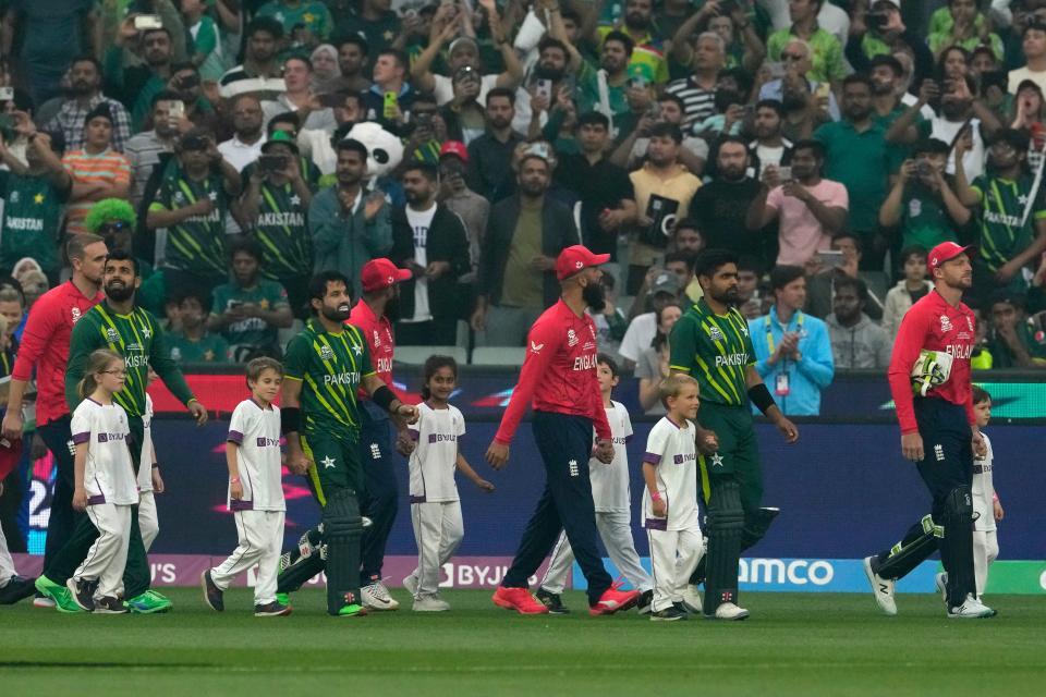 Pakistan and England players walk into the field (AP)