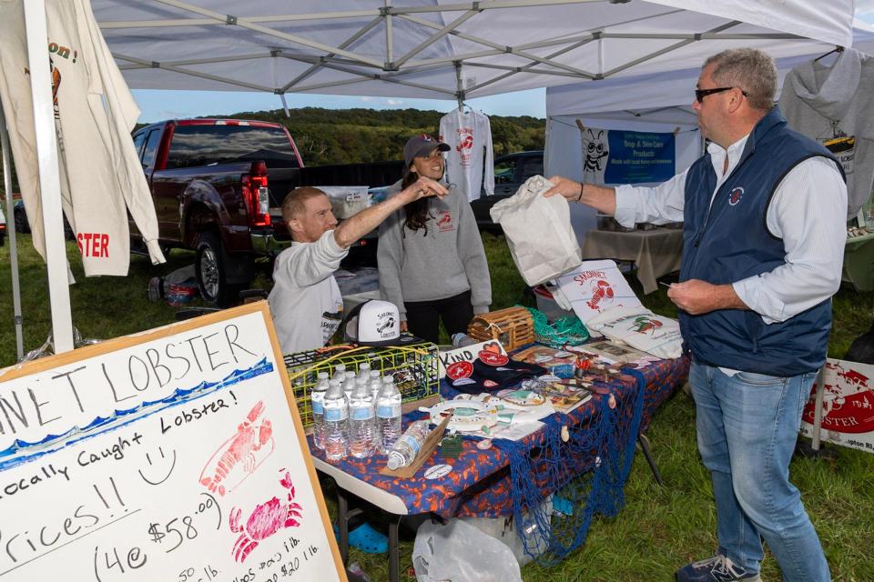 Doug Mataronas of Sakonnet Lobster Co. sells another lobster to a patron at the Sandywoods farmers market.