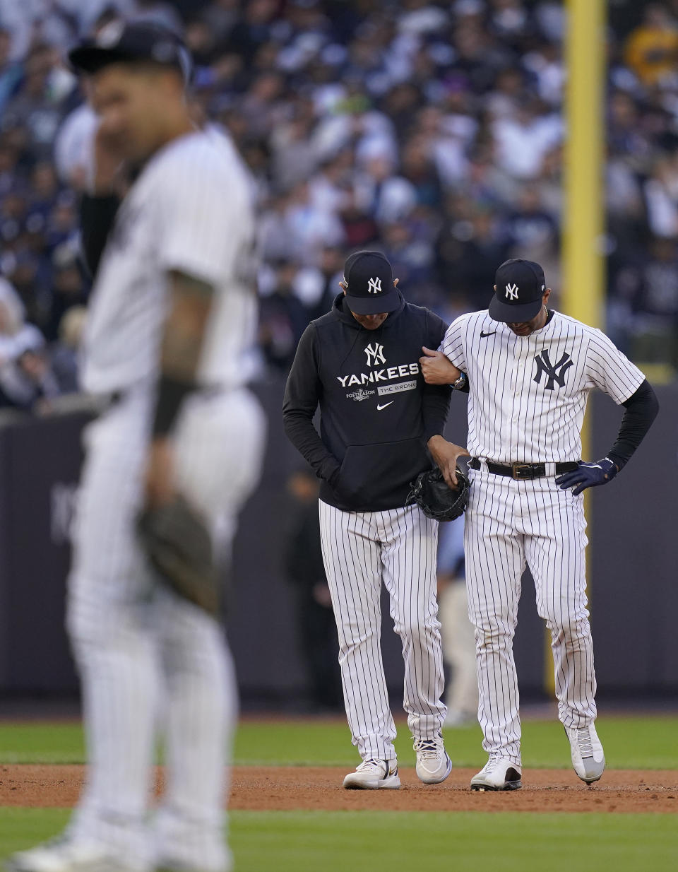 New York Yankees center fielder Aaron Hicks is helped off the field by manager Aaron Boone after colliding with Oswaldo Cabrera during the third inning of Game 5 of an American League Division baseball series against the Cleveland Guardians, Tuesday, Oct. 18, 2022, in New York.(AP Photo/Frank Franklin II)