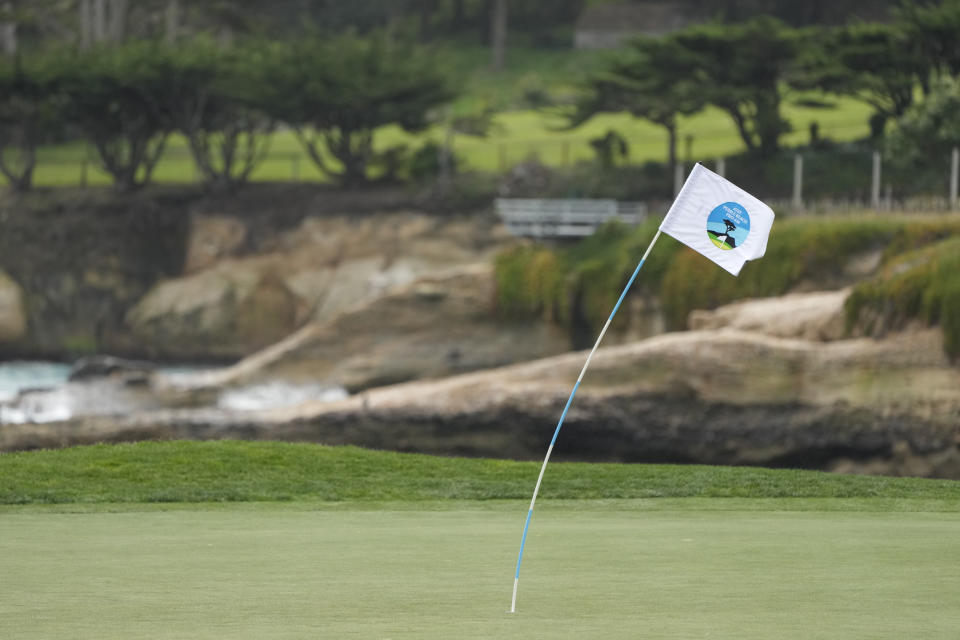 A flagstick on the 18th green of the Pebble Beach Golf Links bends in the strong winds during a practice round of the AT&T Pebble Beach National Pro-Am golf tournament in Pebble Beach , Calif., Wednesday, Jan. 31, 2024. (AP Photo/Eric Risberg)