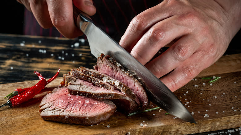 person slicing seared