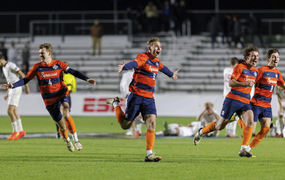 Syracuse's Noah Singlemann (4), Julius Rauch (9), Lorenzo Boselli, second from right, and Jeorgio Kocevski (8) celebrate after defeating Indiana in penalty kicks in the NCAA college soccer tournament final in Cary, N.C., Monday, Dec. 12, 2022. (AP Photo/Ben McKeown)