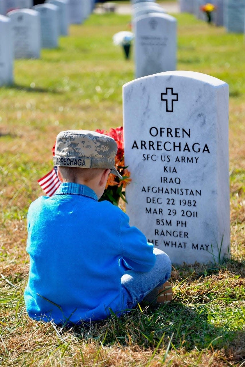 Sgt. 1st Class Ofren Arrechaga's son sits in front of his father's resting place.