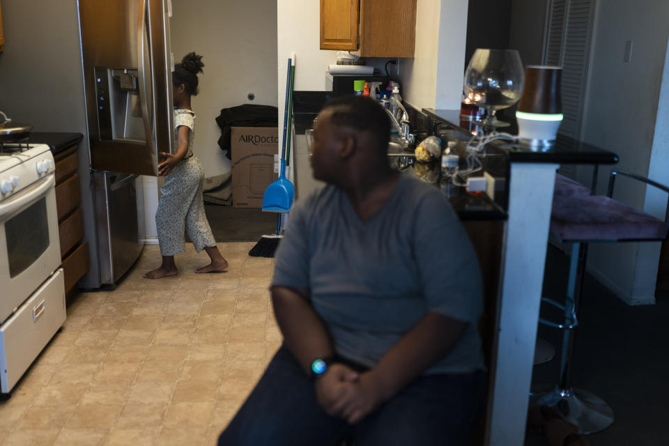 John Simon, a teenager who had a bariatric surgery in 2022, watches as his sister, Haley, opens a refrigerator for food in their apartment in Los Angeles, Monday, March 13, 2023. (AP Photo/Jae C. Hong)
