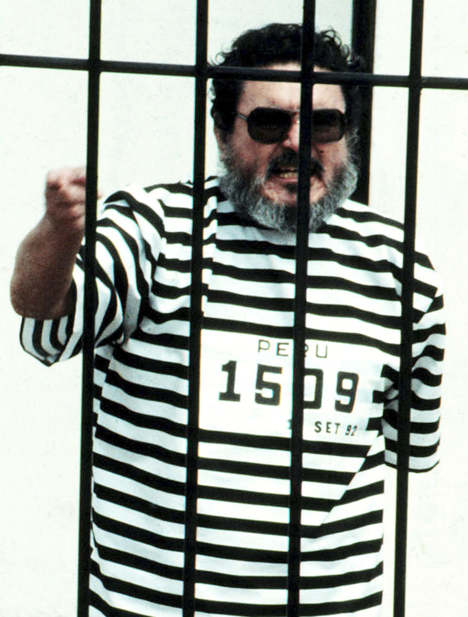 FILE - In this Sept. 1992 file photo, Abimael Guzman, the founder and leader of the Shining Path guerrilla movement, shouts inside of a jail cell after being captured in Lima, Peru. The Peruvian government reported Saturday, Sept. 11, 2021, that Guzman died after an illness. (AP File Photo)