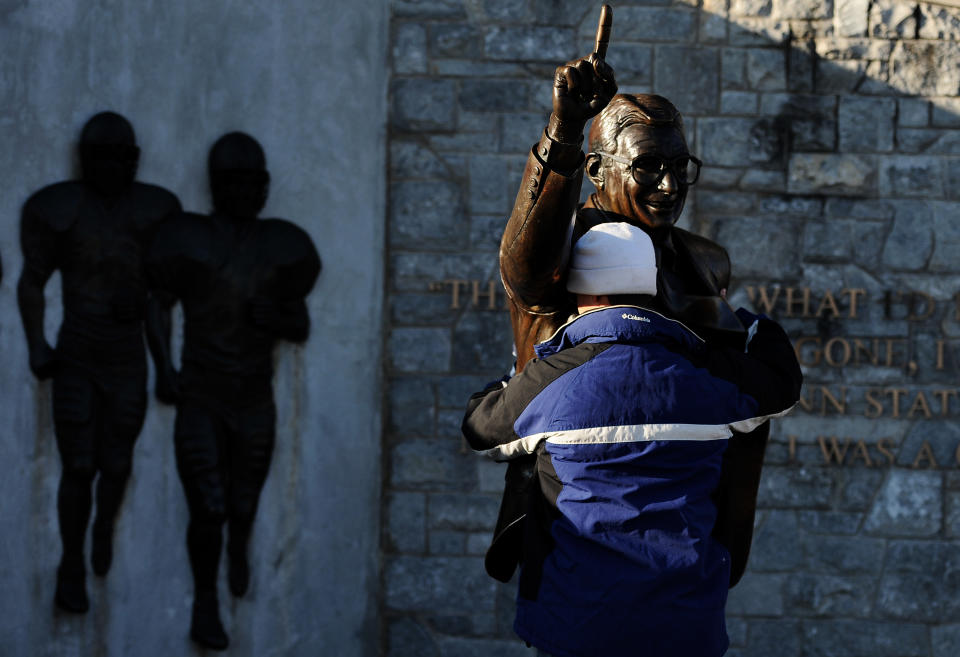 STATE COLLEGE, PA - NOVEMBER 12: A fan pays respect to a statue of former Penn State football coach Joe Paterno before the Penn State against Nebraska football game at Beaver Stadium on November 12, 2011 in State College, Pennsylvania. Head football coach Joe Paterno was fired amid allegations that former Penn State defensive coordinator Jerry Sandusky was involved with child sex abuse. Penn State is playing their final home football game against Nebraska. (Photo by Patrick Smith/Getty Images)