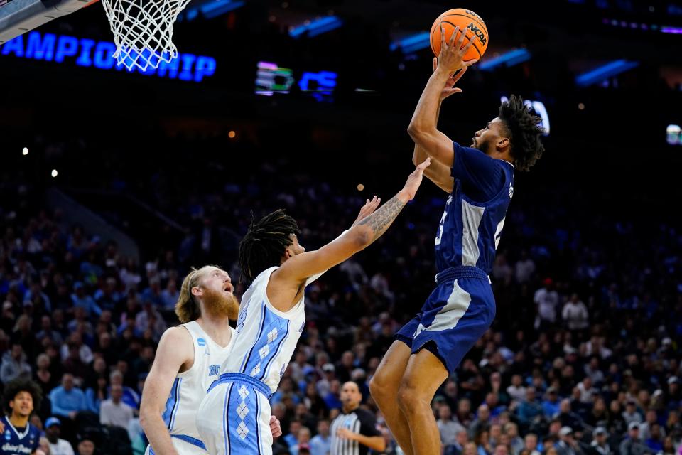 St. Peter's Isiah Dasher, right, goes up for a shot against North Carolina's R.J. Davis, center, and Brady Manek during the first half of a college basketball game in the Elite 8 round of the NCAA tournament, Sunday, March 27, 2022, in Philadelphia. (AP Photo/Matt Rourke)