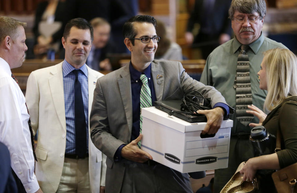 FILE - Rep. Joel Fry, R-Osceola, center, carries a box from his desk following adjournment of the legislative session on June 5, 2015, at the Statehouse in Des Moines, Iowa. Thousands of Iowa residents would be expected to lose Medicaid and food stamp benefits under a bill given final legislative approval Thursday, April 13, 2023, and sent to Gov. Kim Reynolds. Fry said the bill takes nothing away from people who are eligible for benefits. (AP Photo/Charlie Neibergall, File)