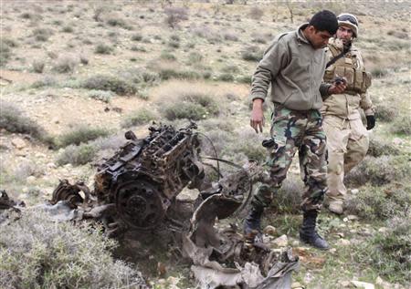 A Lebanese army soldier inspects the remains of a car which the army blew up, after it was suspected to have contained explosives, in east Bekaa March 17, 2014. REUTERS/Ahmad Shalha