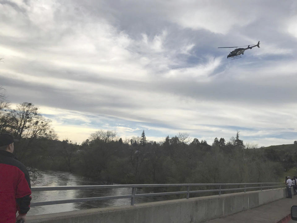 In this Sunday, March 17, 2019 photo provided by the Stanislaus Consolidated Fire Protection District Authorities, fire and rescue personnel search for a 5-year-old girl who was swept away by a swollen river in Central California. The Stanislaus Sheriff's Department said the girl slipped off rocks and fell into the Stanislaus River Sunday afternoon. The department said several relatives and bystanders tried to rescue her but couldn't reach her. The department said in a statement crews on boat and a helicopter searched until darkness Sunday but called off their search because of the river's dangerous conditions. (Stanislaus Consolidated Fire Protection District via AP)