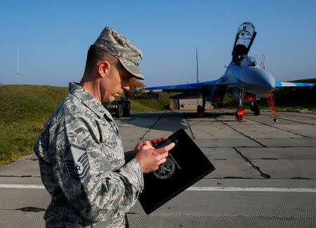 A serviceman of the U.S. Army stands in front of a Ukrainian Su-27 fighter jet during the Clear Sky 2018 multinational military drills at Starokostiantyniv Air Base in Khmelnytskyi Region, Ukraine October 12, 2018. REUTERS/Gleb Garanich