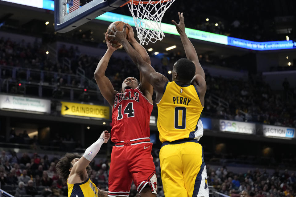 Chicago Bulls forward Malcolm Hill (14) shoots around Indiana Pacers forward Reggie Perry (0) during the second half of an NBA basketball game in Indianapolis, Friday, Feb. 4, 2022. (AP Photo/AJ Mast)