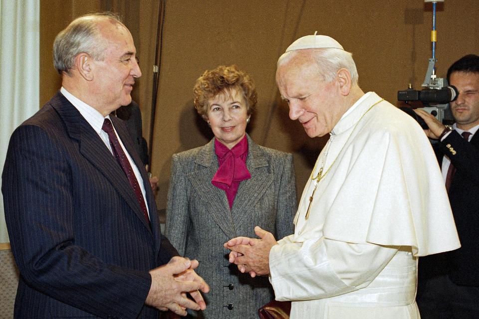 FILE - Pope John Paul II talks to Soviet President Mikhail Gorbachev, as Raisa looks on, during a private visit to the Vatican City, Sunday, Nov. 18, 1990. When Mikhail Gorbachev is buried Saturday at Moscow's Novodevichy Cemetery, he will once again be next to his wife, Raisa, with whom he shared the world stage in a visibly close and loving marriage that was unprecedented for a Soviet leader. Gorbachev's very public devotion to his family broke the stuffy mold of previous Soviet leaders, just as his openness to political reform did. (AP Photo/Gianni Foggia, File)