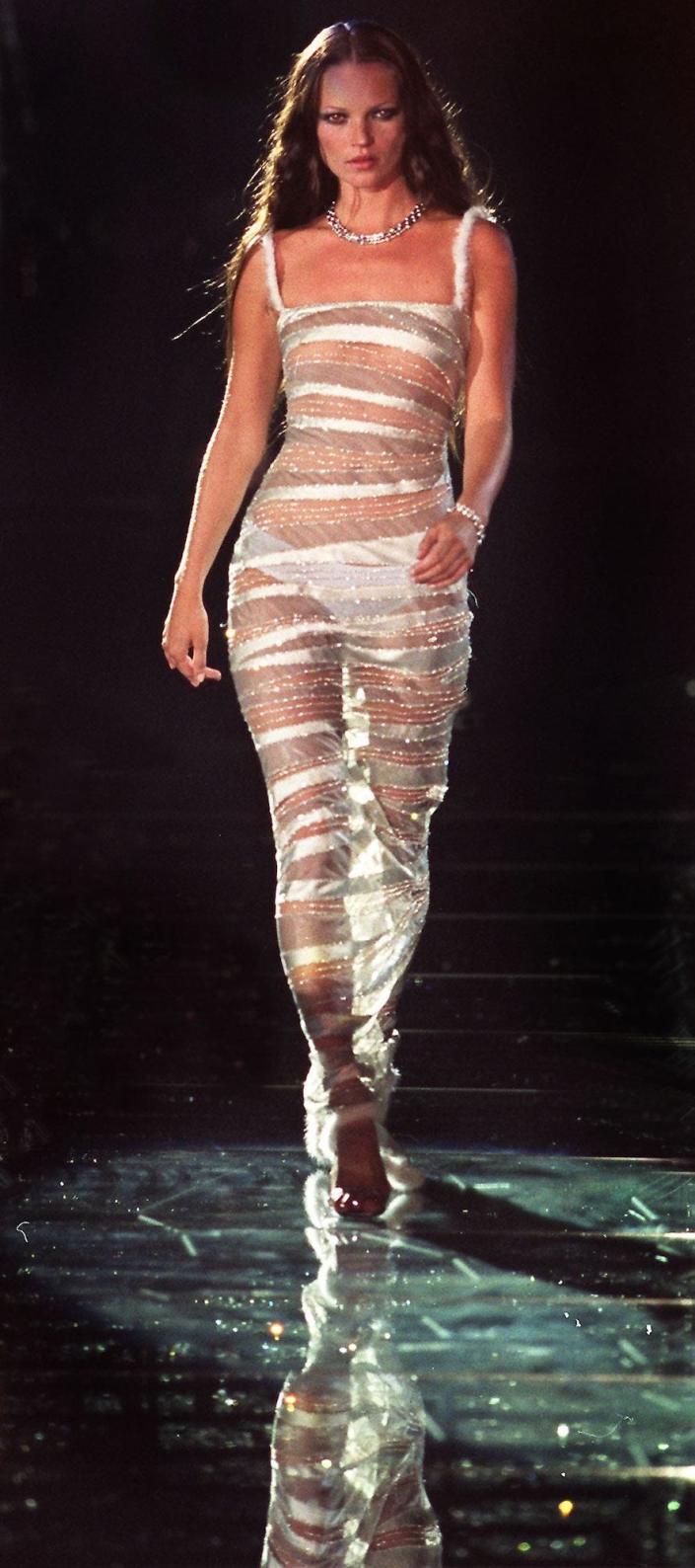 Kate Moss wears Versace during a charity runway show on June 9, 1999.