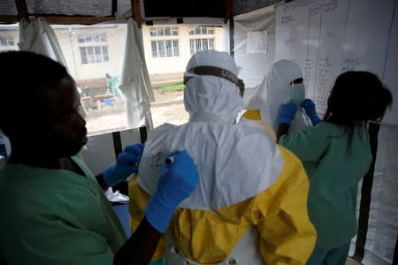 FILE PHOTO: Health workers dress in Ebola protective suits before starting their shift at an Ebola transit centre in the town of Katwa near Butembo