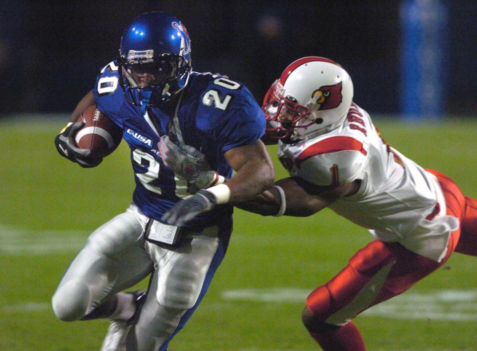 Louisville's Kerry Rhodes (1) dives for Memphis  running back DeAngelo Williams (20) during the first quarter on Thursday, Nov. 4, at the Liberty Bowl in Memphis.