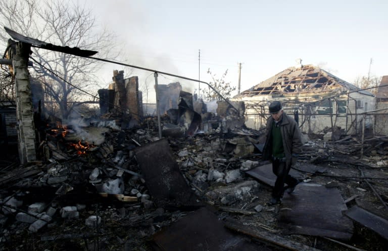 A resident of Svatove, in the Lugansk region of Ukraine, walks through the rubble of his destroyed home on October 30, 2015