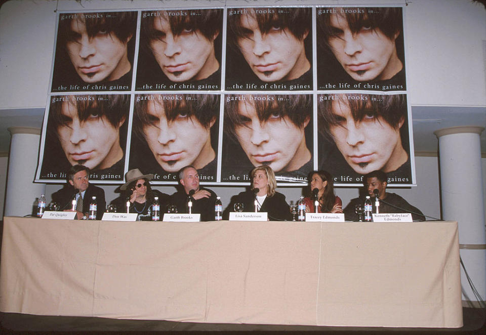 Panelists seated at a table with promotional posters for "The Life of Chris Gaines" in the background