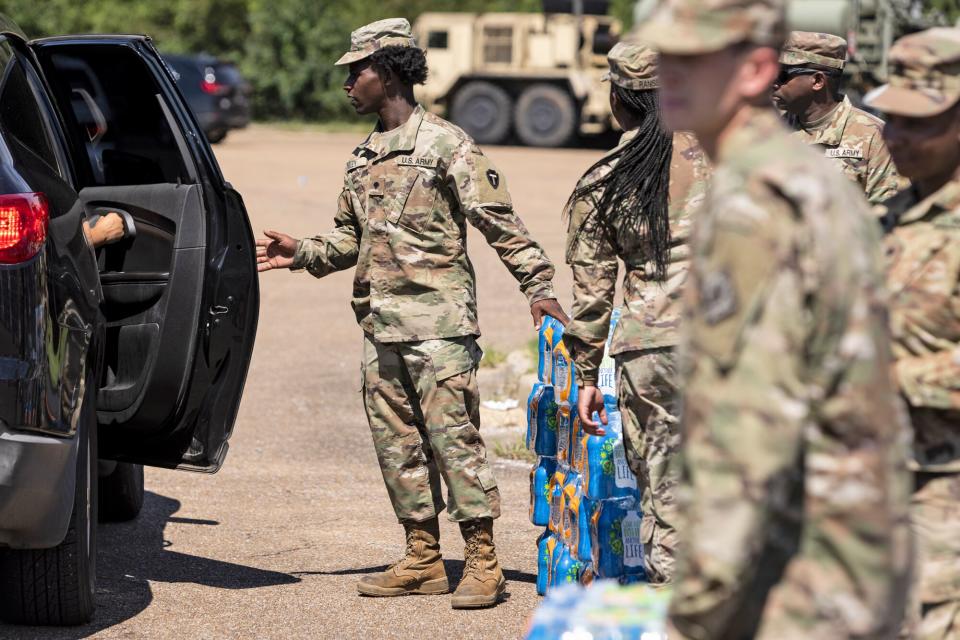 Members of the Mississippi National Guard hand out bottled water at Thomas Cardozo Middle School in response to the water crisis on September 01, 2022 in Jackson, Mississippi. Jackson has been experiencing days without reliable water service after river flooding caused the main treatment facility to fail.