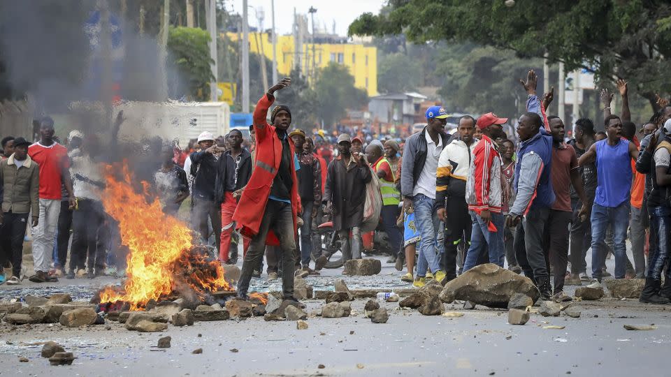 Protesters stand by a burning barricade on a street in the Mathare neighborhood of Nairobi. - AP